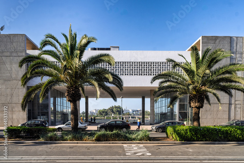 Modern Building Entrance With Palm Trees And Busy Street In Sunny Urban Setting, Agadir, Morocco