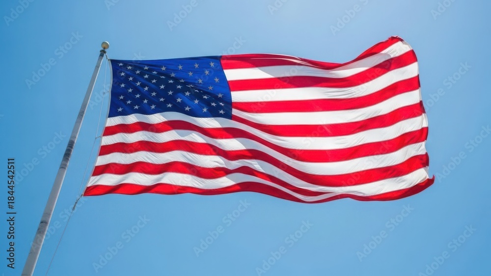 Obraz premium American flag waving against bright blue sky, showcasing vibrant red, white, and blue colors. Iconic American flag displays stars and stripes, symbolizing national unity and liberty for country.