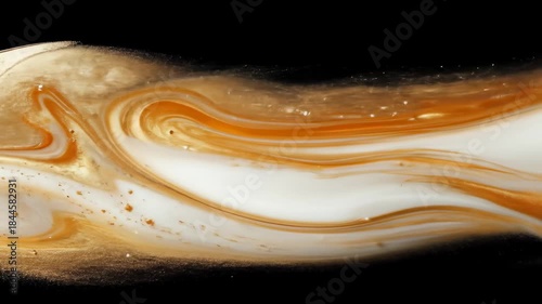 Swirls of gold, white, and amber paint mix on black background