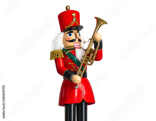 Wooden nutcracker soldier in red uniform, holding a golden trumpet, against black