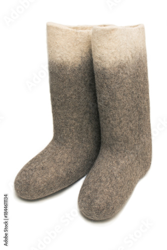 Felt boots with a dark bottom and light top on a white background