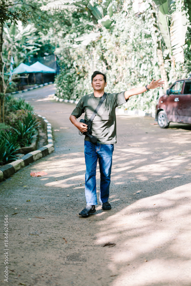 Fototapeta premium Enthusiastic man showing direction in a lush park area