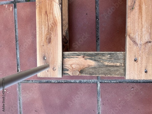 Vista del tubo pvc en el palet de madera. El agujero permite insertar el tubo de plástico para la estructura del invernadero, mostrando trabajo vista aérea, área limpia, sin serrín.