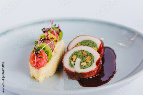 Gourmet Dish Featuring Colorful Veggies and Succulent Stuffed Chicken with Rich Sauce on Elegant Plate