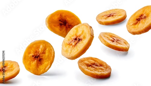 Isolated dried banana slices falling against a white background