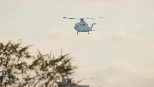 A helicopter is about to land in a heliport in London, UK in the sunset