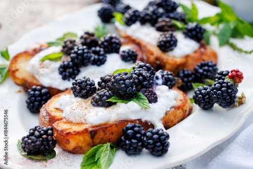 French toasts with cream cheese and fresh blackberries, close-up view. Delicious vegetarian breakfast or dessert