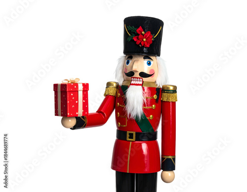 A festive wooden soldier in a red uniform, holding a wrapped gift box, on black