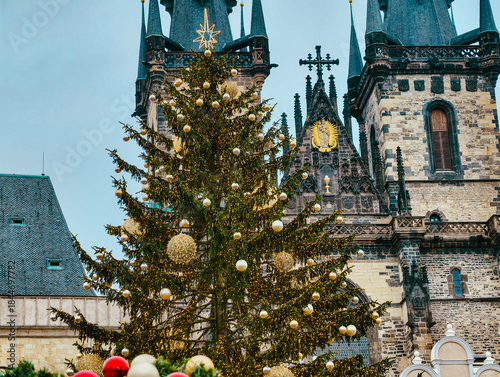 Christmas Tree with Gold Ornaments Before Prague Gothic Cathedral Towers Holiday Market Scene Winter Background