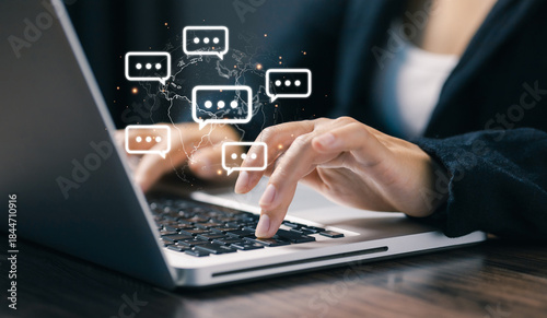 Hands typing on a laptop with floating chat bubbles over a world map, representing global online communication, instant messaging, remote collaboration, and digital business interaction.