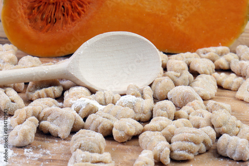 Close-up of Raw Homemade Pumpkin Gnocchi with Flour and Butternut Squash Background