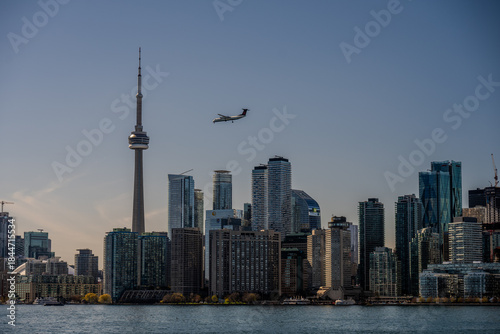 Photography Airplane flying over downtown skyline and CN Tower in Toronto