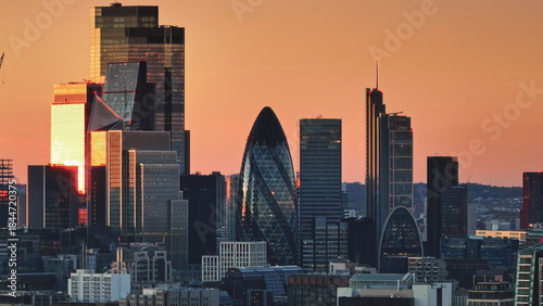 Photography United Kingdom, London: Illuminating warm sunset colors over London's modern cityscape, highlighting iconic skyscrapers like the Gherkin in a stunning panorama