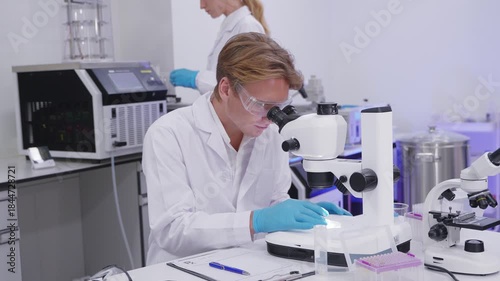 Researcher examines samples in modern laboratory setting with equipment