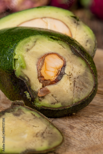 a ripe fresh green avocado cut into pieces, an avocado with soft flesh cut into pieces long ago, the seed has changed color from the air