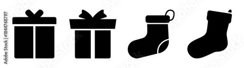 A set of four black silhouette icons representing christmas gifts and stockings