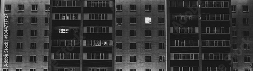 Foto Luminous windows in an apartment building at night, where each tenant has his ow