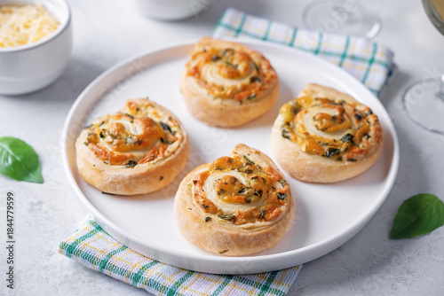 Basil garlic cheese roll cake pinwheel in a plate on a white isolated background