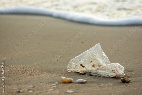 Plastic Waste Scattered on Beach Sand. Plastic waste on beaches is a serious global problem.
