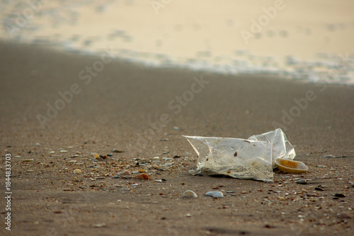 Plastic Waste Scattered on Beach Sand. Plastic waste on beaches is a serious global problem.