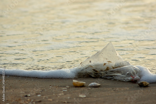 Plastic Waste Scattered on Beach Sand. Plastic waste on beaches is a serious global problem.
