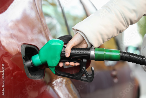 Young woman refueling car a...
