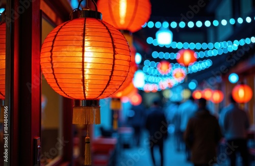 Red paper lanterns glowing along a bustling nighttime street with bokeh lights
