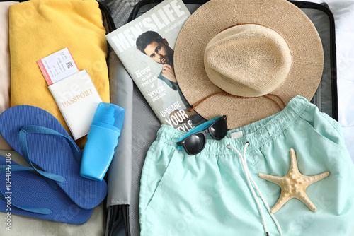 Open suitcase with men's sw...