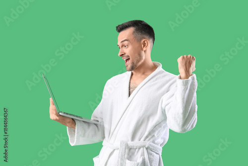 Happy young man in bathrobe...