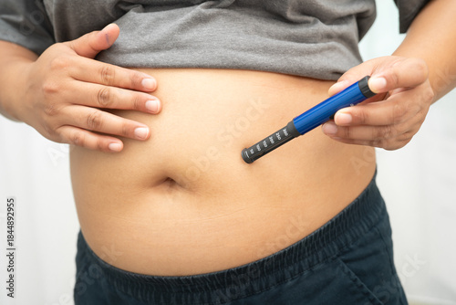 Quadro em tela Asian woman injecting herself diabetes injecting insulin in stomach at home