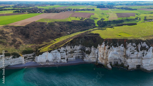 Aerial drone view of picturesque coastal limestone cliffs and the English Channel town of Etretat, France
