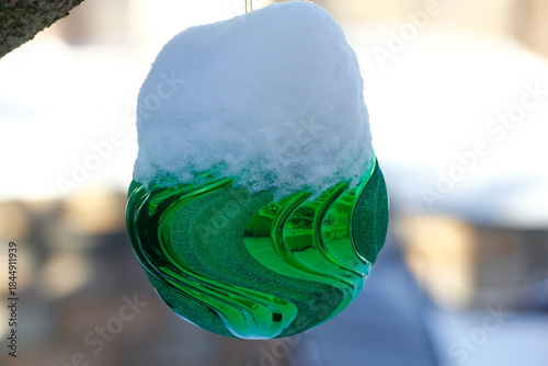 Large, Snow-Covered Christmas Ornament on a Outdoor Tree
