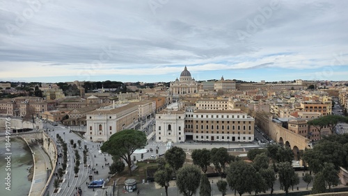 Fototapeta Naklejka Na Ścianę i Meble -  Rome, Italy – 12 January 2025. The view from Castel Sant’Angelo captures the Tiber River, tree-lined streets, and St. Peter’s Basilica rising at the end of Via della Conciliazione.