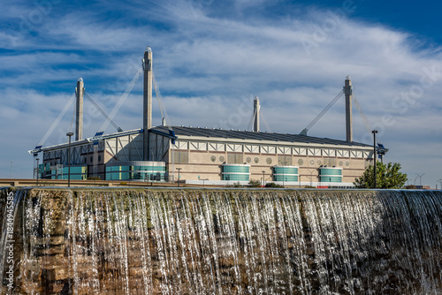 San Antonio, Texas, USA - December 2, 2025:  Exterior view of the San Antonio Alamodome, a multi-purpose stadium, with water feature in the foreground.
