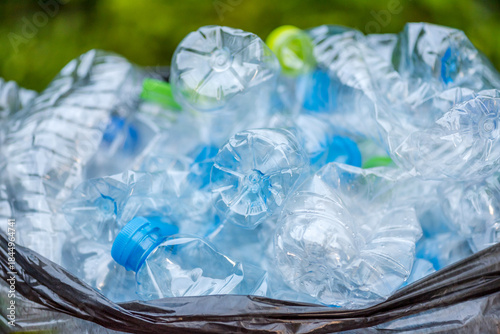 Plastic bottles in black garbage bags waiting to be taken to recycle.