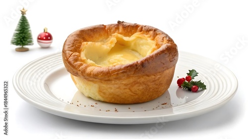 Golden yorkshire pudding on a plate with christmas decorations isolated on white background