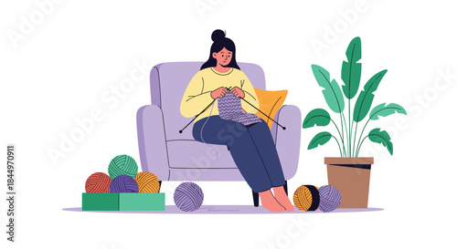 Young woman sitting comfortably in an armchair and knitting with colorful balls of yarn, enjoying a relaxing hobby at home.
