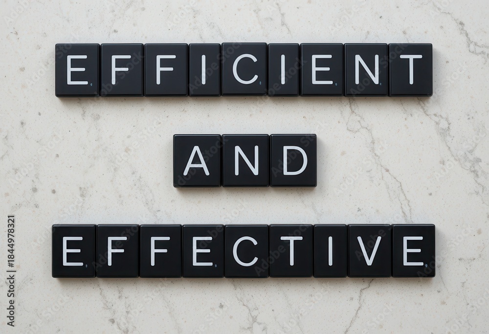 Fototapeta premium Black Letter Tiles Displaying Efficient and Effective on Marble Background