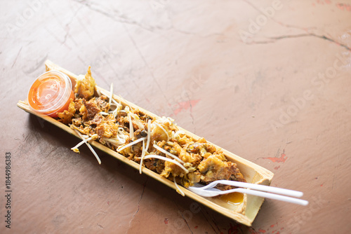 Pad Thai with fried mussels served in a bamboo tube.