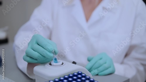 Close up laboratory worker uses vortex for mixing samples in HPLC vials. 