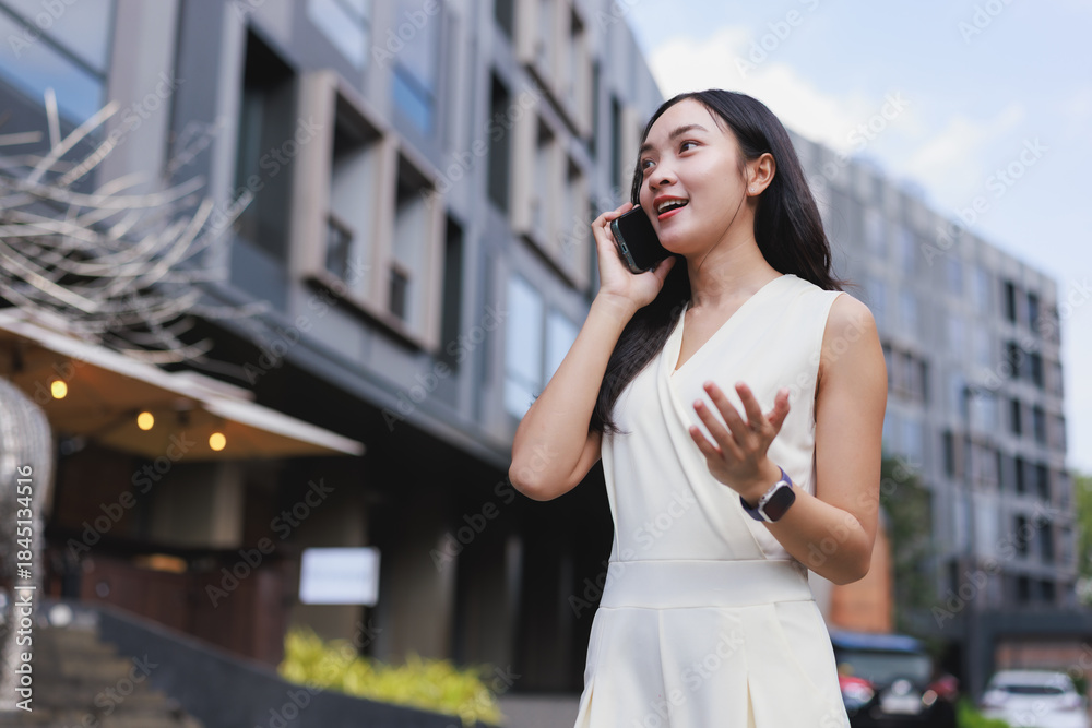 Fototapeta premium Young businesswoman talking smartphone communicating in city