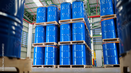 Warehouse stocked with numerous blue steel drums, barrels tank, which are containers used for shipping bulk cargo. chemical storage, warehouse management