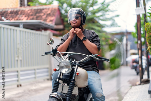 Asian Indonesian Man Wearing Helmet While Riding Motorcycle on Urban Street