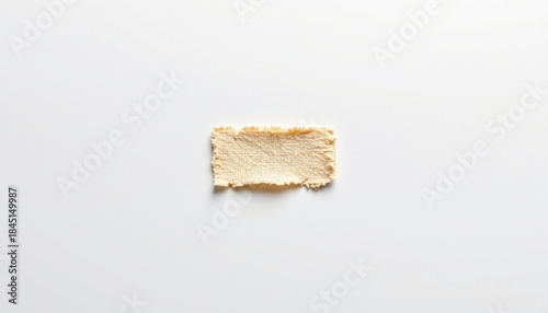 A close up of a torn piece of paper against a white background. The paper is crumpled and has a jagged edge, indicating it was not neatly torn but rather ripped in a hurry