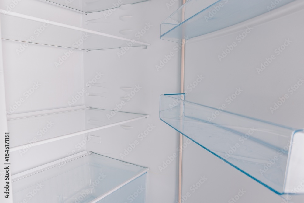 Fototapeta premium An Inside Look at an Empty Refrigerator Showcasing Its Spacious Shelves and Clear Glass Racks Perfect for Organizing Food and Beverages
