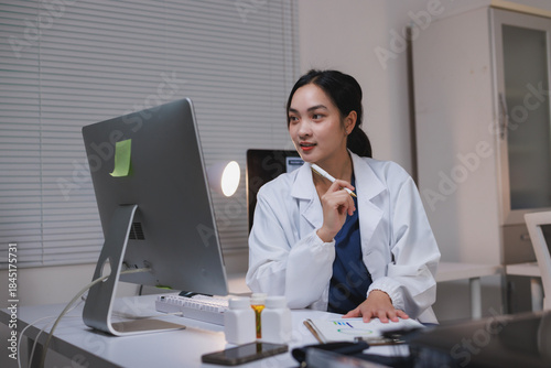 Female doctor working late analyzing patient data on computer