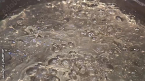 Close-Up of Bubbles Forming in Boiling Water in a Pan