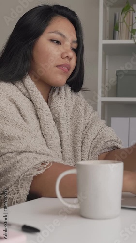 Young latina woman drinking coffee at home office desk