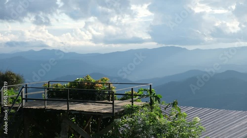 Landscape image of mountain views and cloudy sky from wooden terrace viewpoint