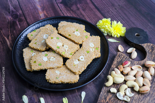 Til gajak, a traditional Indian winter sweet made with sesame seeds, jaggery, ghee, and dryfruits. Crunchy til chikki festive treat for Makar Sankranti. Tilgul. sesame candy. Copy Space. Winter food.